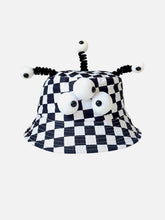 Chapeau de dessin animé à trois yeux à carreaux